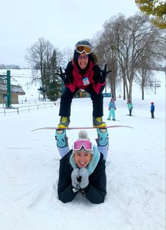 two people on skis doing a handstand in the snow