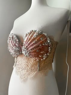 a mannequin wearing a bra with beads and pearls