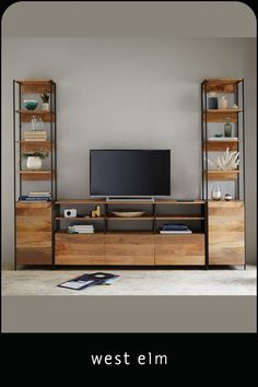 the west elm entertainment center is made out of wood and has shelves with bookshelves