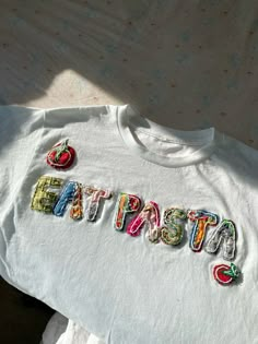 a t - shirt with the word fiesta written in colorful letters and fruit on it