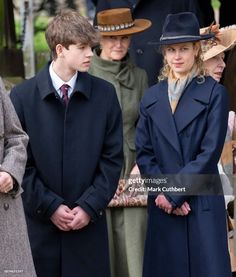 people in coats and hats standing next to each other