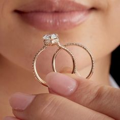 a close up of a person holding a ring with a diamond on it's side