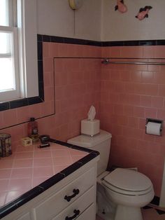 a bathroom with pink tiles on the walls