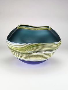 a blue and green bowl sitting on top of a white table