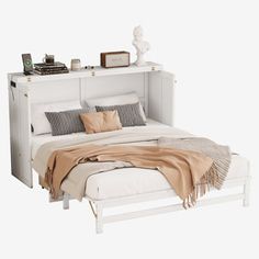 a white bed with pillows and blankets on top of it next to a night stand