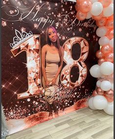 a woman standing in front of a backdrop with balloons