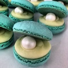 there are many green and yellow macaroons with white eggs on them in the middle