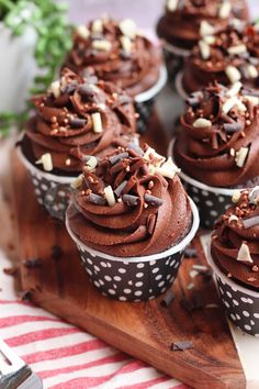 cupcakes with chocolate frosting and sprinkles on a wooden tray