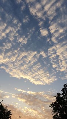 the sky is filled with clouds and trees