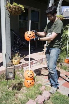 a man is decorating pumpkins in the yard