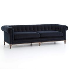 a blue velvet couch with wooden legs on an isolated white background for use in interior design