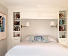 a white bed with built in bookshelves above it and pillows on the bottom