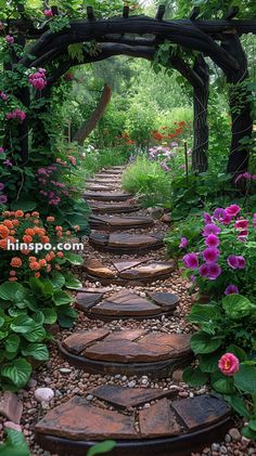 a stone pathway surrounded by flowers and greenery