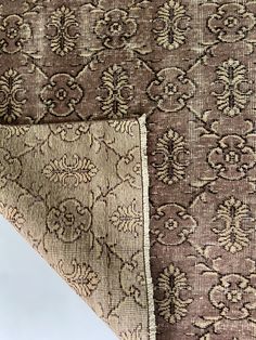 the side of a brown and tan patterned fabric with an intricate floral design on it