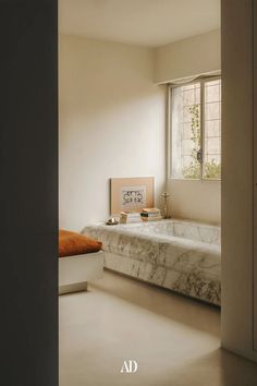 an empty room with a marble bed and window