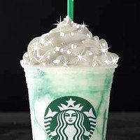 a starbucks drink with whipped cream and a green straw