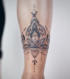 a woman's leg with a tattoo on it and an ornate design in the middle