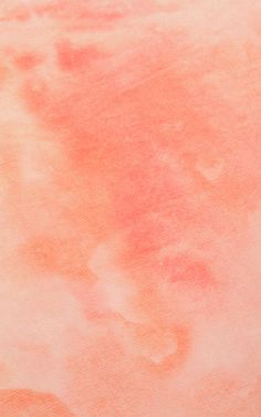 an orange and pink watercolor background with some stains on it's surface,