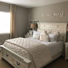 a white bed sitting in a bedroom next to a window