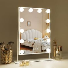 a vanity mirror with lights on it next to a vase and other items in front of the mirror