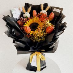 a bouquet of flowers is wrapped in black paper