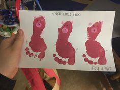 a person holding up a piece of paper that has three little pigs on it and the other one is pink