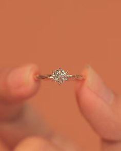 a person holding an engagement ring in their hand with the diamond setting on it's side