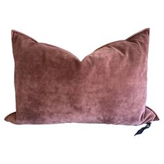 a pink velvet pillow on a white background