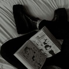 a person laying on a bed reading a book