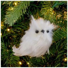 a white bird ornament hanging from a christmas tree