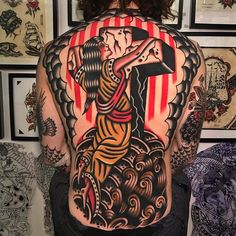 the back of a woman's body with tattoos on it, and an american flag behind her