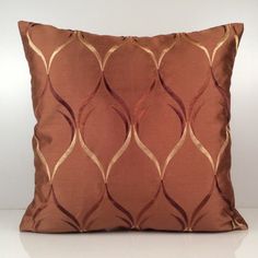 a brown and gold pillow on a white surface