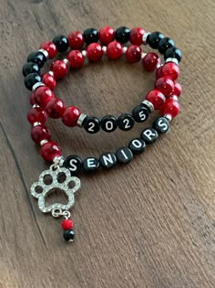 two red and black beaded bracelets with a dog's paw on them