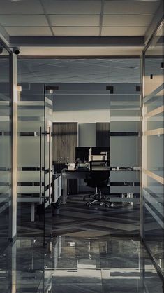 an office with glass partitions and marble flooring