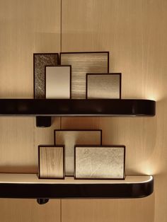 a shelf with several different shades of glass on it's sides and some lights in the middle