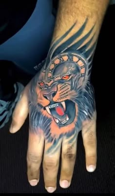 a man's hand with a tattoo on it and a lion head in the middle