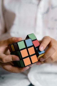 a person holding a rubik cube in their hands