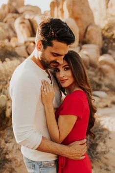 a man and woman embracing each other in the desert