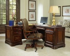 an office desk with a computer on it and a lamp in the corner next to it