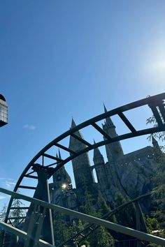 an amusement park with a roller coaster in the foreground and a castle in the background