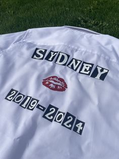 the back of a white jacket with black and red stickers on it that says sydney