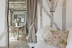 a living room filled with furniture next to a wooden door and window covered in curtains