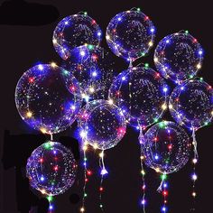 a bunch of balloons that are glowing in the dark