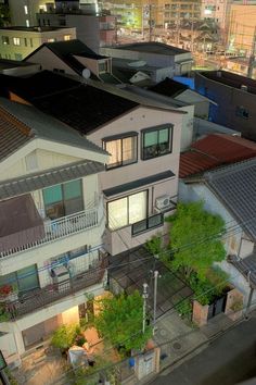 an aerial view of some houses in the city at night with lots of windows and balconies