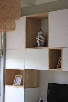 a living room filled with furniture and a flat screen tv sitting on top of a wooden shelf