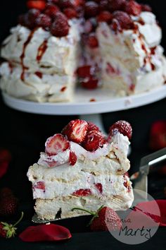 the cake is covered with strawberries and icing on it's sides, while the rest of the cake has been sliced