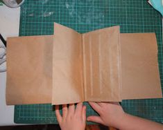 someone is making a book out of brown paper