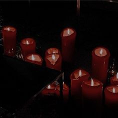 many red candles are lit in the dark