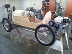 an old car is being worked on in a garage with other tools and equipment around it