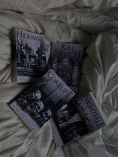 three books laying on top of a bed next to each other in front of a white comforter